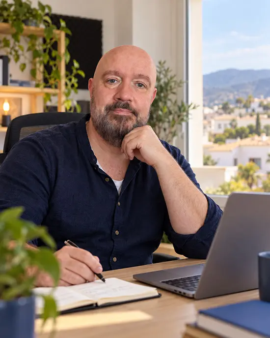 Eric Dieperink schrijft aan zijn bureau met een Spaans uitzicht op de achtergrond